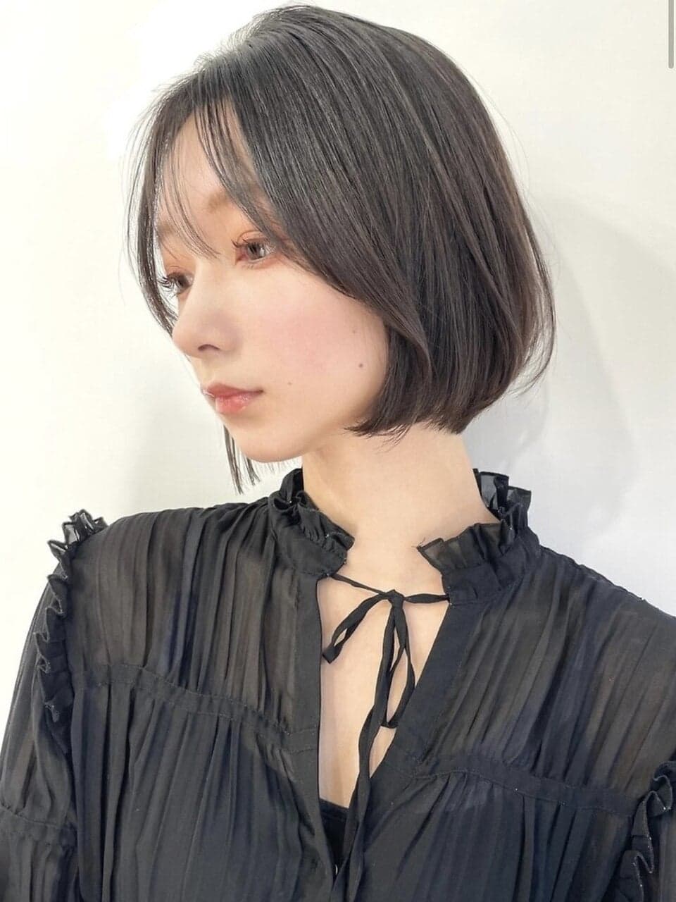 前髪ありで内巻きに収まるダークカラーのボブ(PEEPS&Suu.)